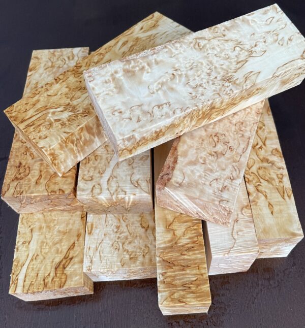 A set of ten curly birch handle blocks in a pile.