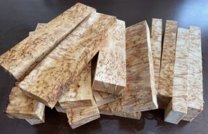 A collection of 16 curly birch scales, featuring a spectacular display of natural swirling grain patterns.